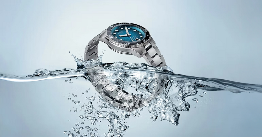 Tissot Seastar dive watch on a steel bracelet breaking the surface of the water in a burst of spray