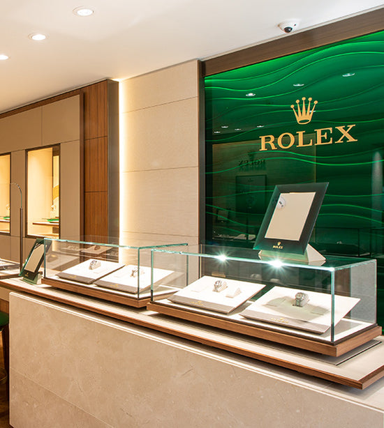 The Rolex Showroom at Michael Spiers in Truro. The Rolex logo is visible on the wall with 4 Rolex watches visible on the counter in glass cases.
